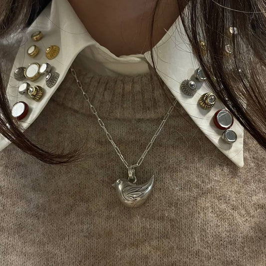 Necklace with a pendant worn by a person, close-up on a neutral background