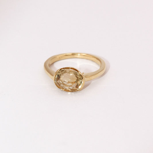 Gold ring with a round gemstone on a white background