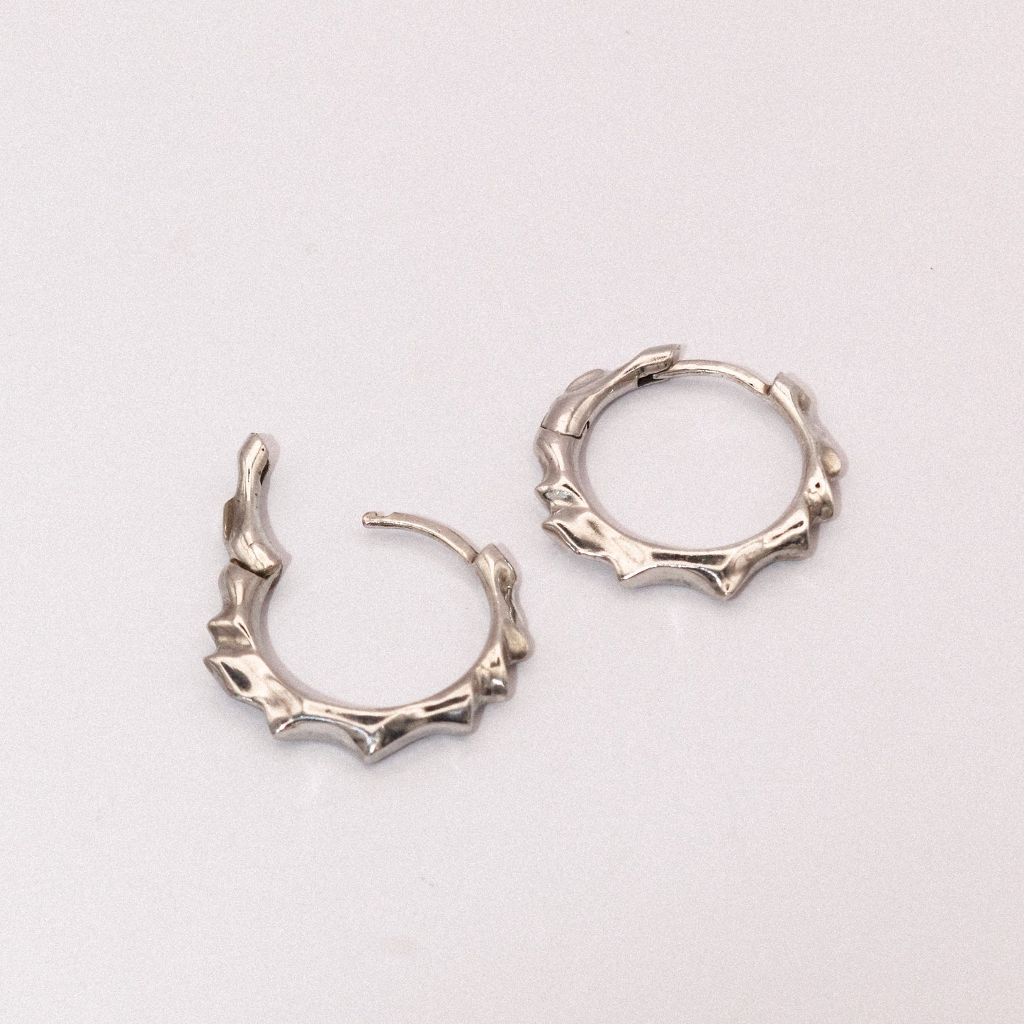 Pair of silver hoop earrings on a light gray background