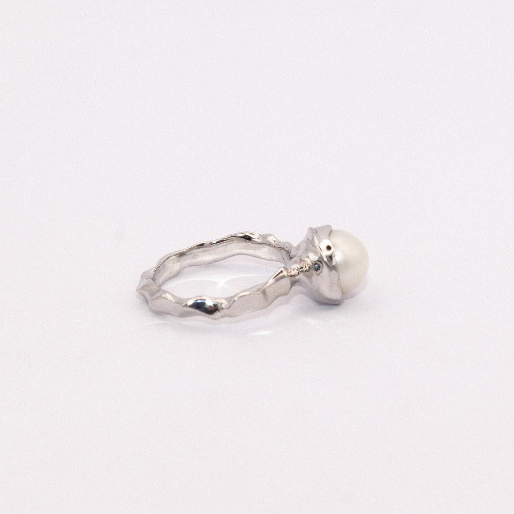 Silver ring with a pearl on a white background