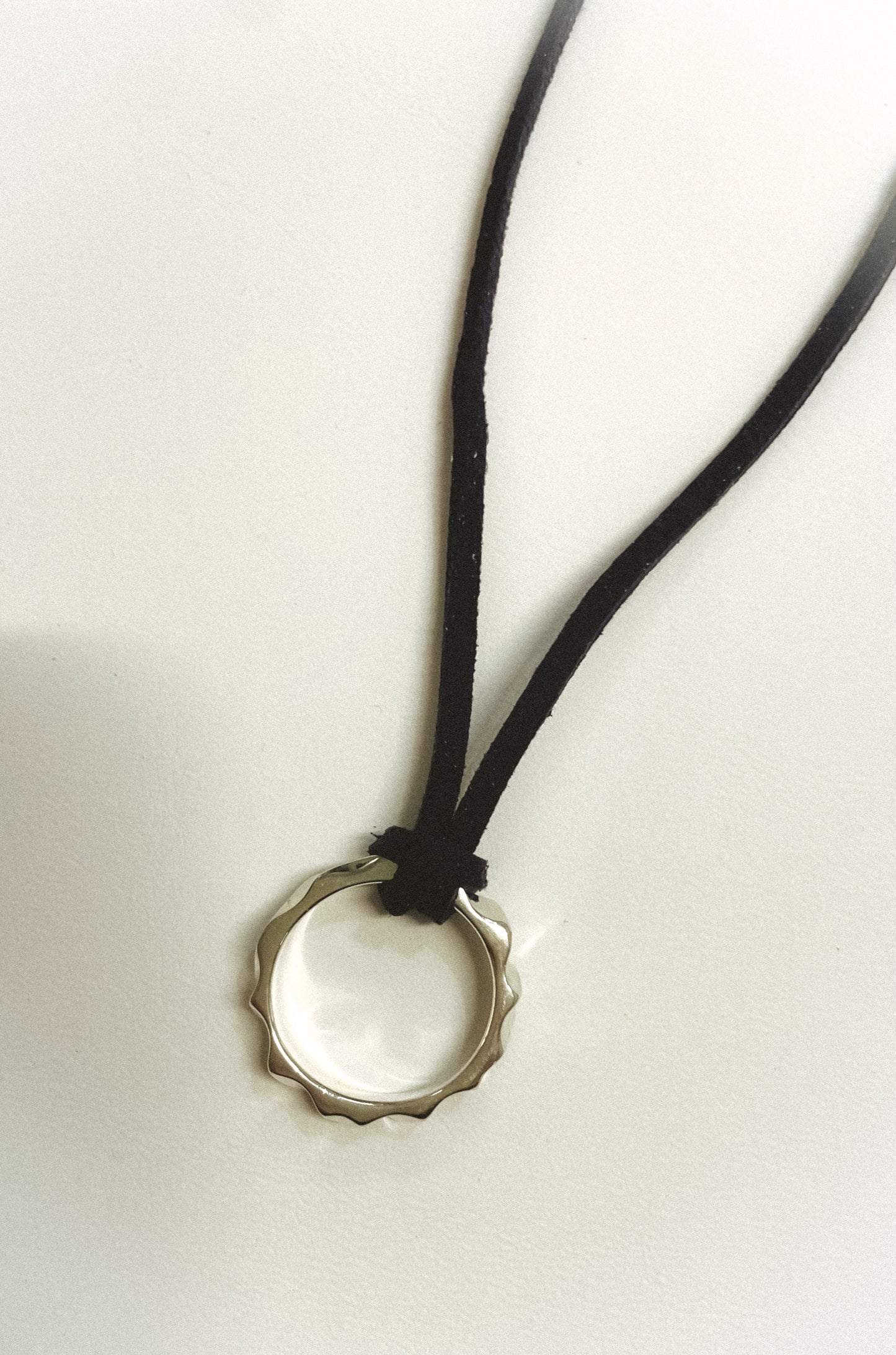 Necklace with a bottle cap pendant on a white background
