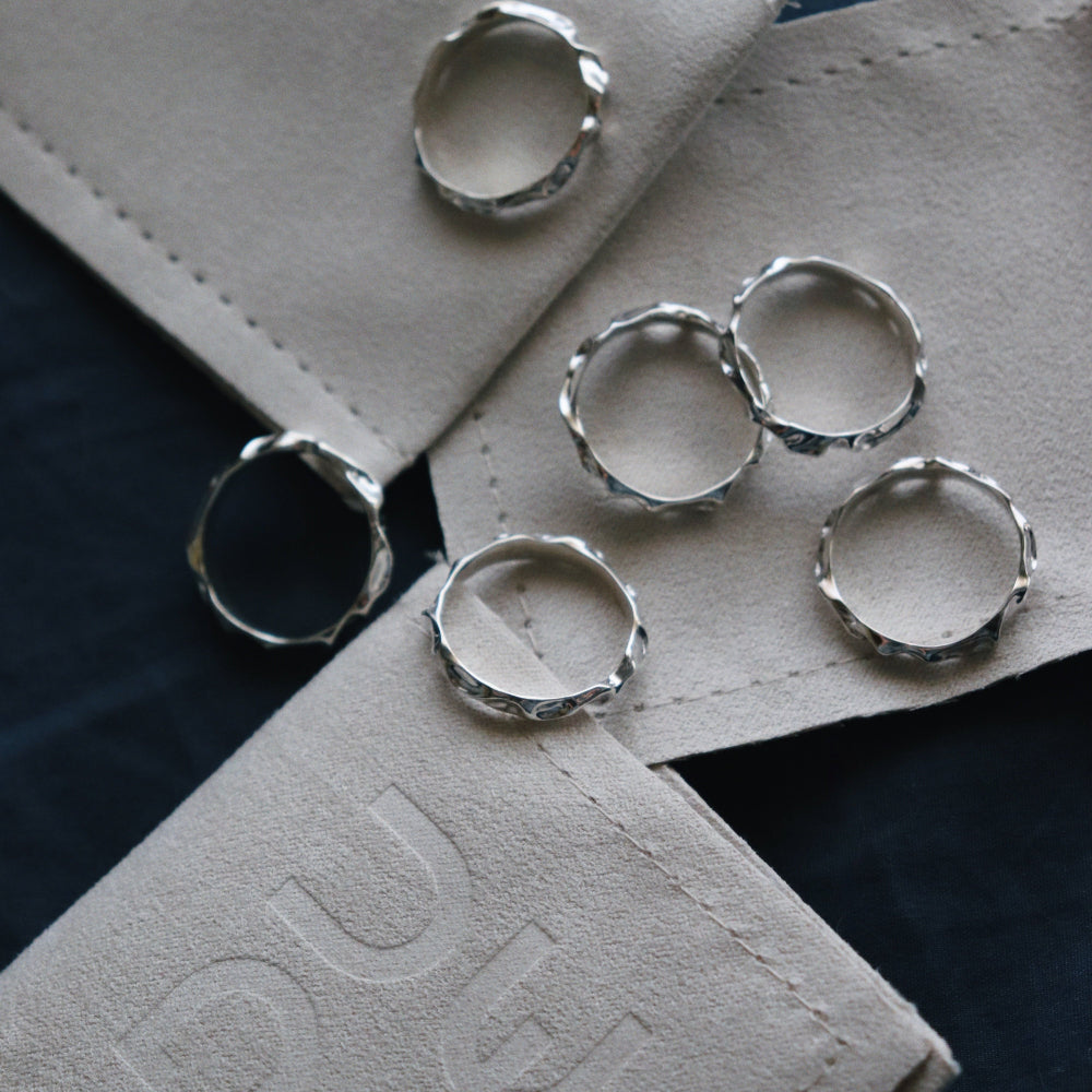 Silver rings on a textured surface with 'EVE' branding.