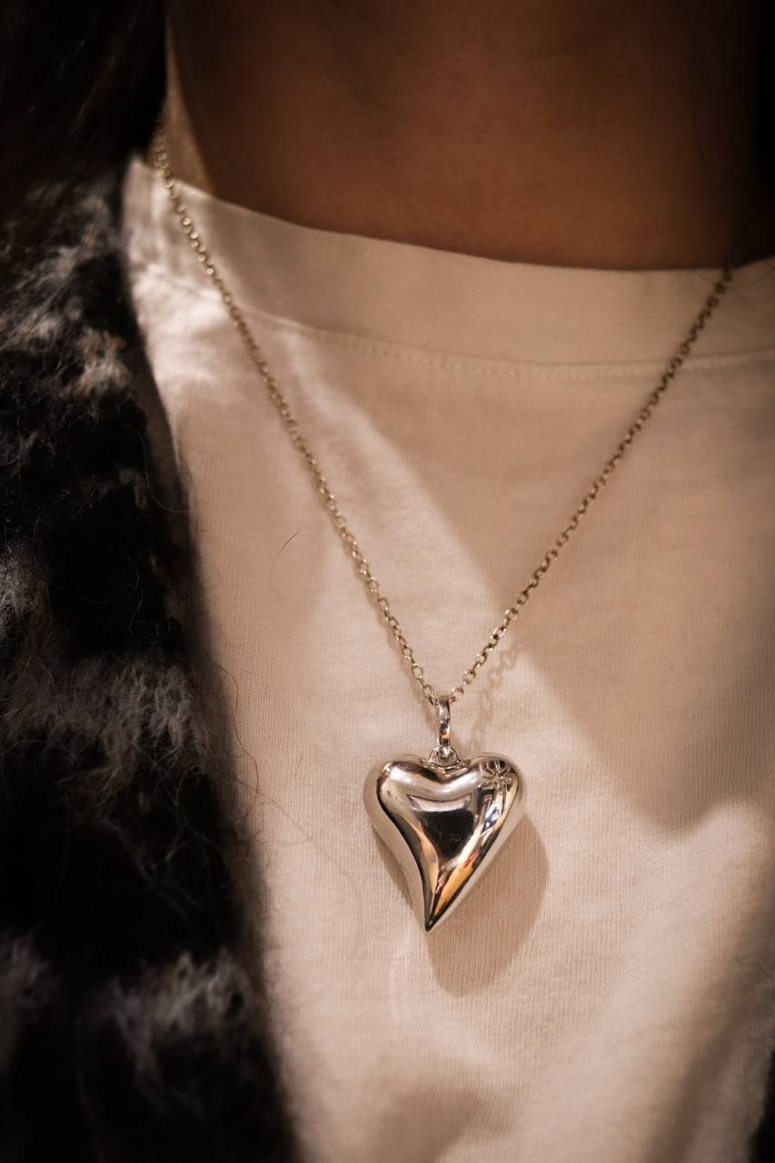 Heart-shaped pendant necklace on a person wearing a light-colored top.