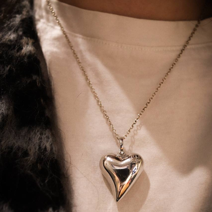 Heart-shaped pendant necklace on a person wearing a light-colored top.