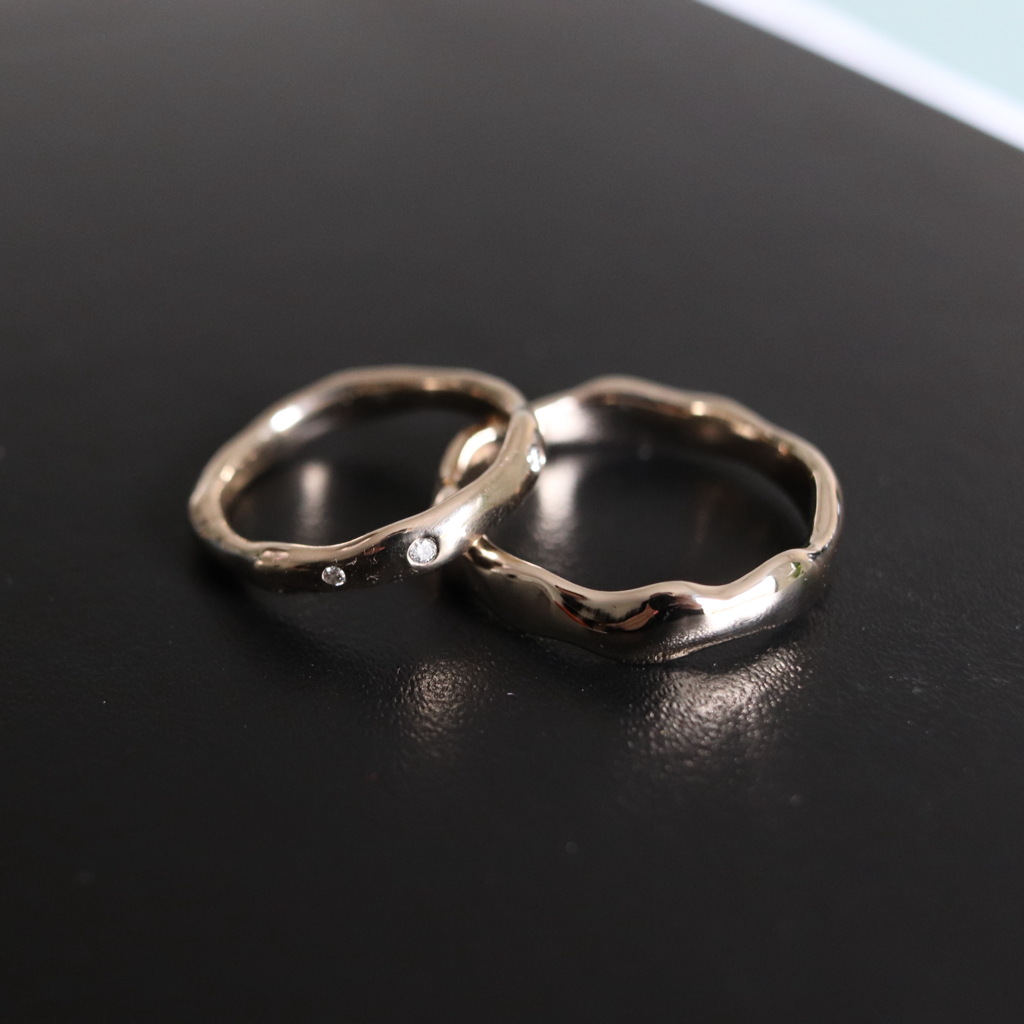 Two silver rings on a black surface