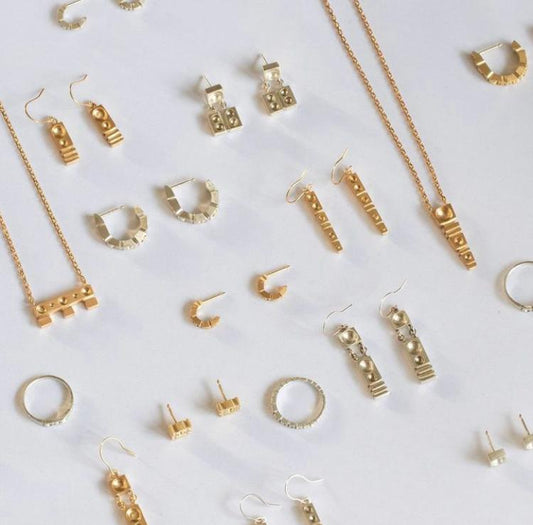 Collection of gold jewelry including earrings and necklaces on a white background
