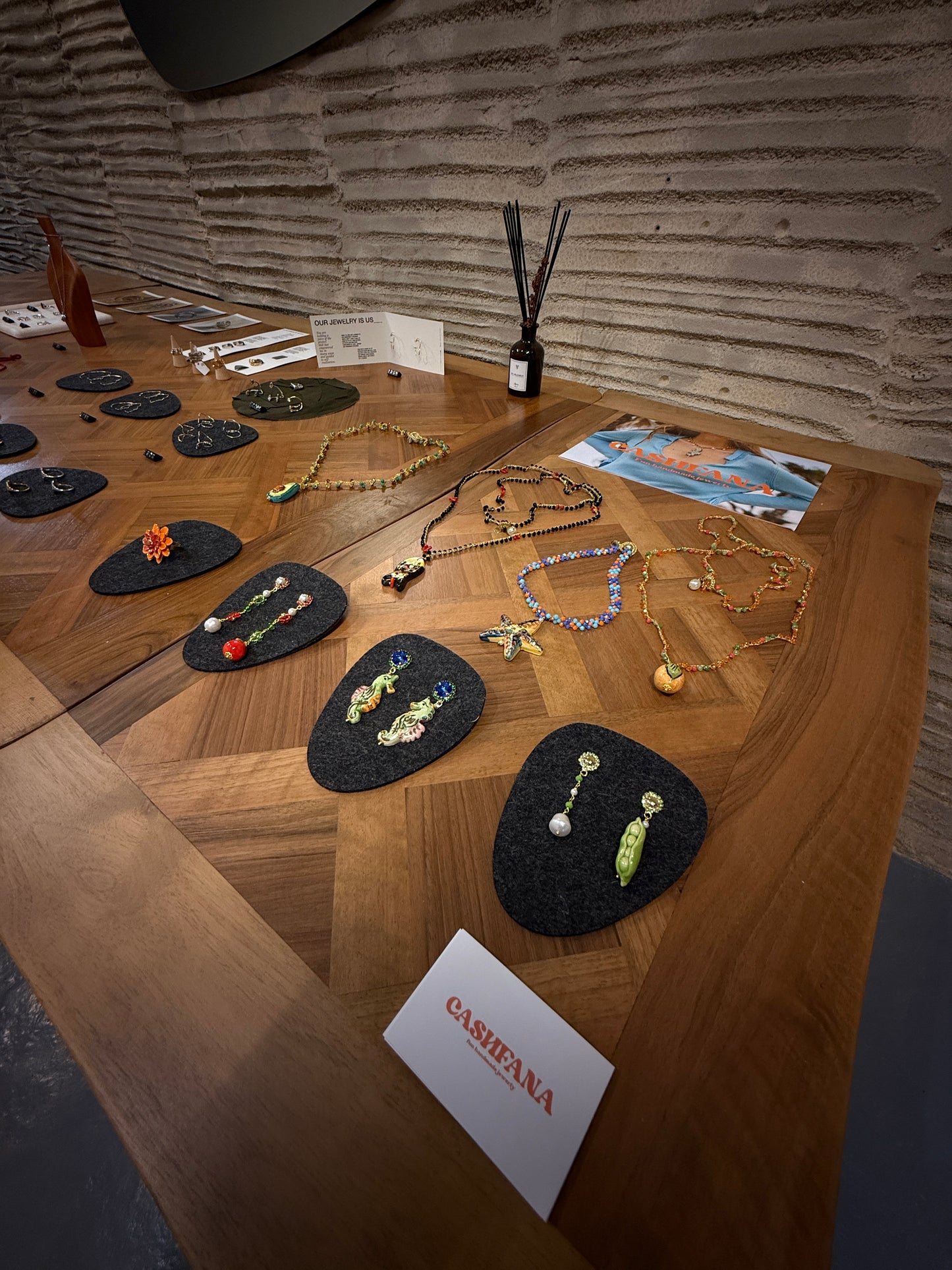 Jewelry displayed on a wooden table with a Cashfana card.