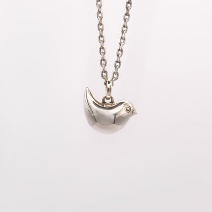 Silver bird-shaped pendant on a chain against a white background
