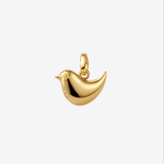 A polished gold bird charm pendant with a small heart detail on its side, shown against a plain light gray background.