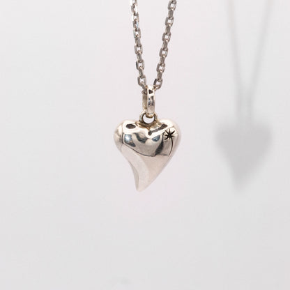 Silver heart-shaped pendant necklace on a light gray background
