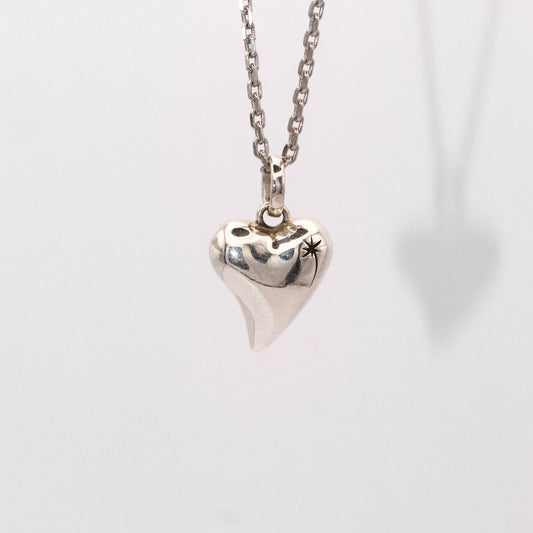 Silver heart-shaped pendant necklace on a light gray background