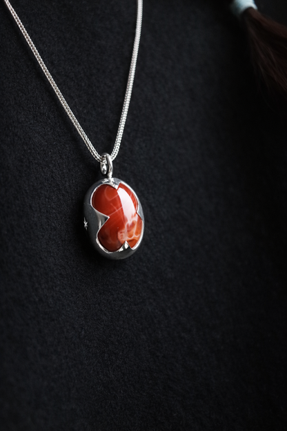 Necklace with a red pendant on a dark background