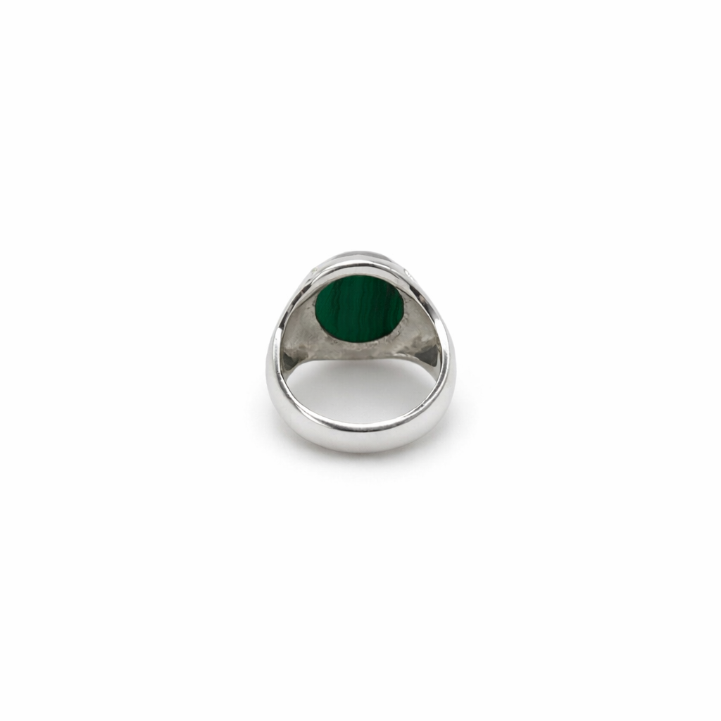 Silver ring with a green stone on a white background