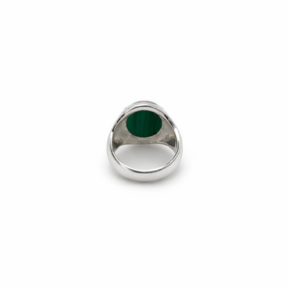 Silver ring with a green stone on a white background