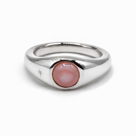 Silver ring with a pink gemstone on a white background