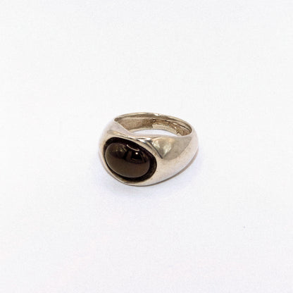 Silver ring with a dark gemstone on a white background
