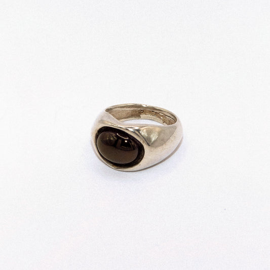 Silver ring with a dark gemstone on a white background