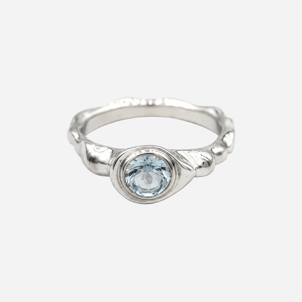 Silver ring with a blue gemstone on a white background