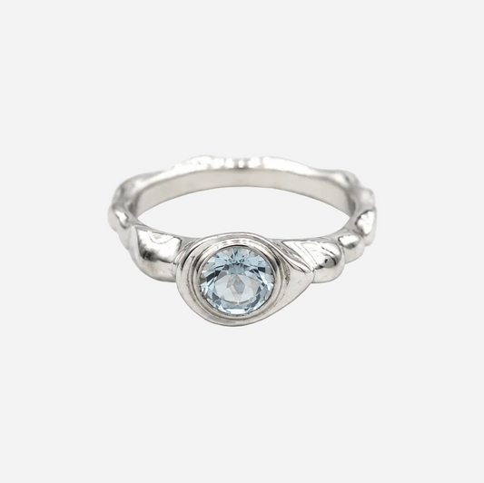 Silver ring with a blue gemstone on a white background