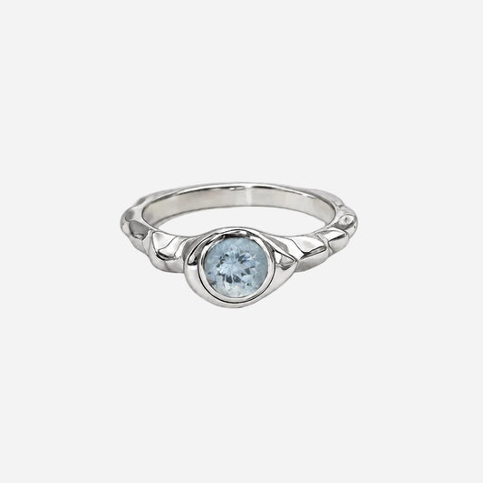Silver ring with a blue gemstone on a white background