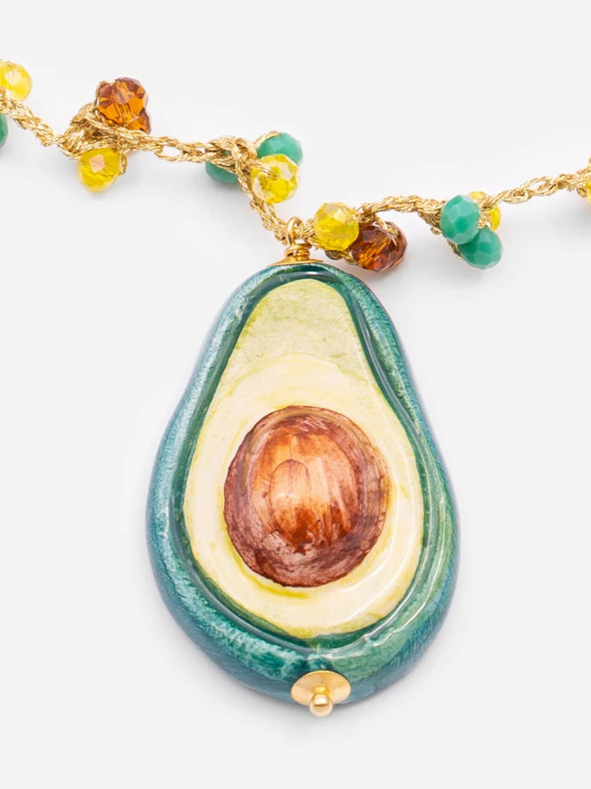Avocado-shaped pendant on a chain with beads against a white background