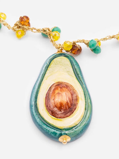 Avocado-shaped pendant on a chain with beads against a white background