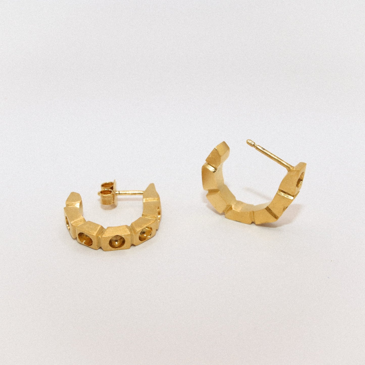 Gold hoop earrings on a light gray background