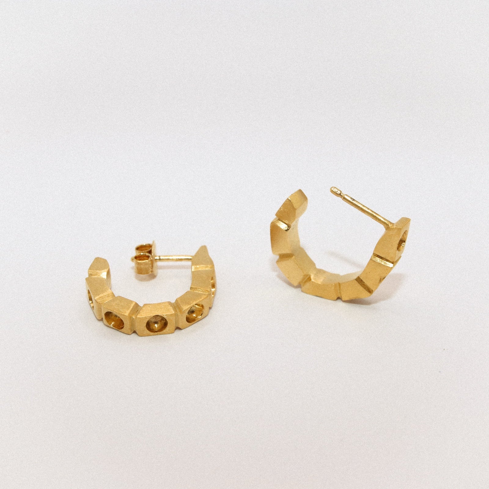 Gold hoop earrings on a light gray background