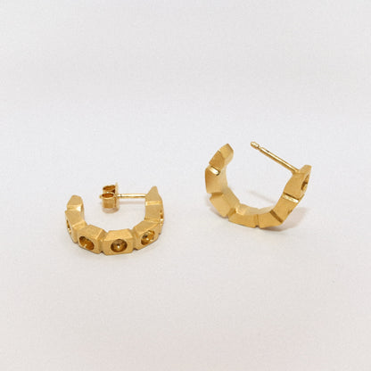 Gold hoop earrings on a light gray background