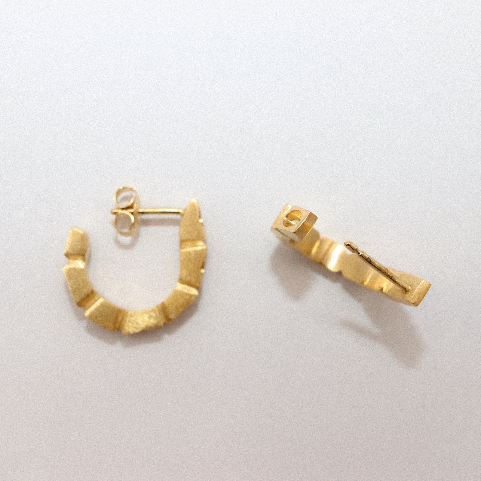 Gold hoop earrings on a light gray background