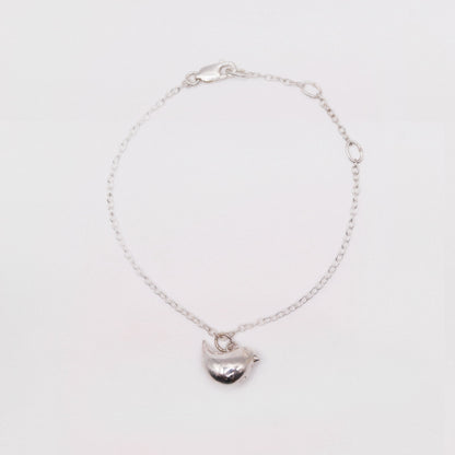 Silver bracelet with a heart-shaped charm on a white background