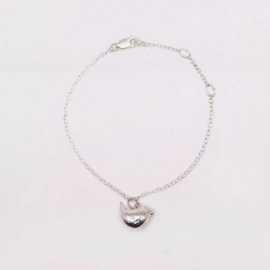 Silver bracelet with a heart-shaped charm on a white background