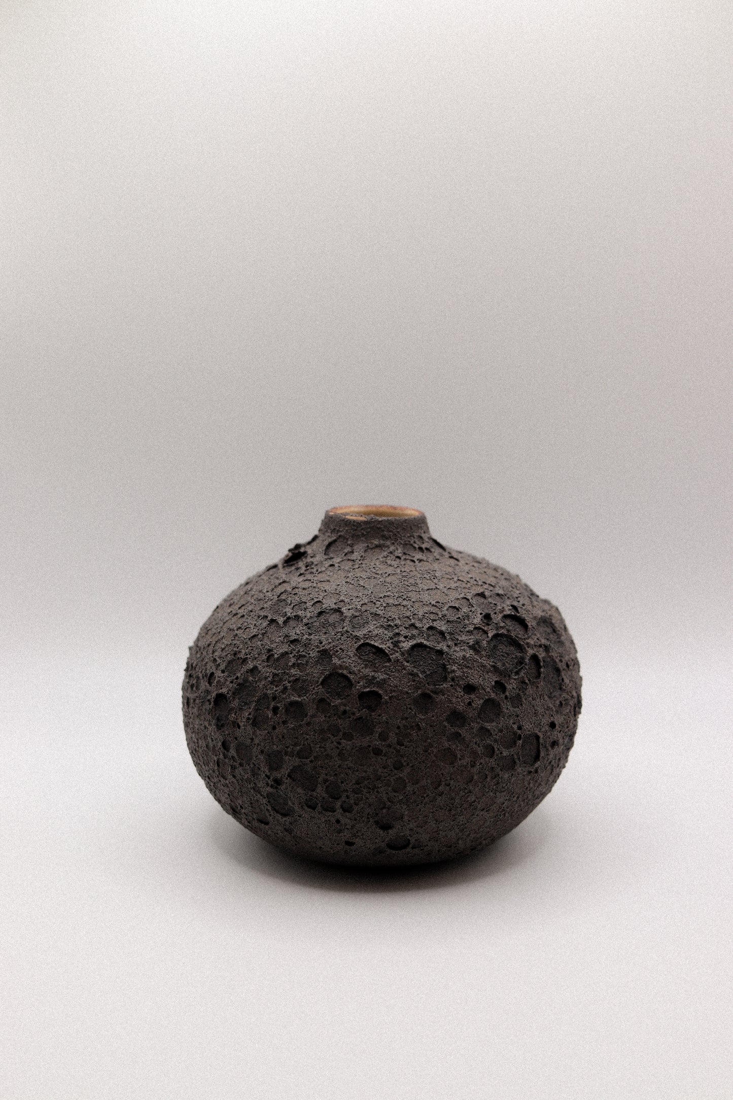 Black textured ceramic vase on a white background