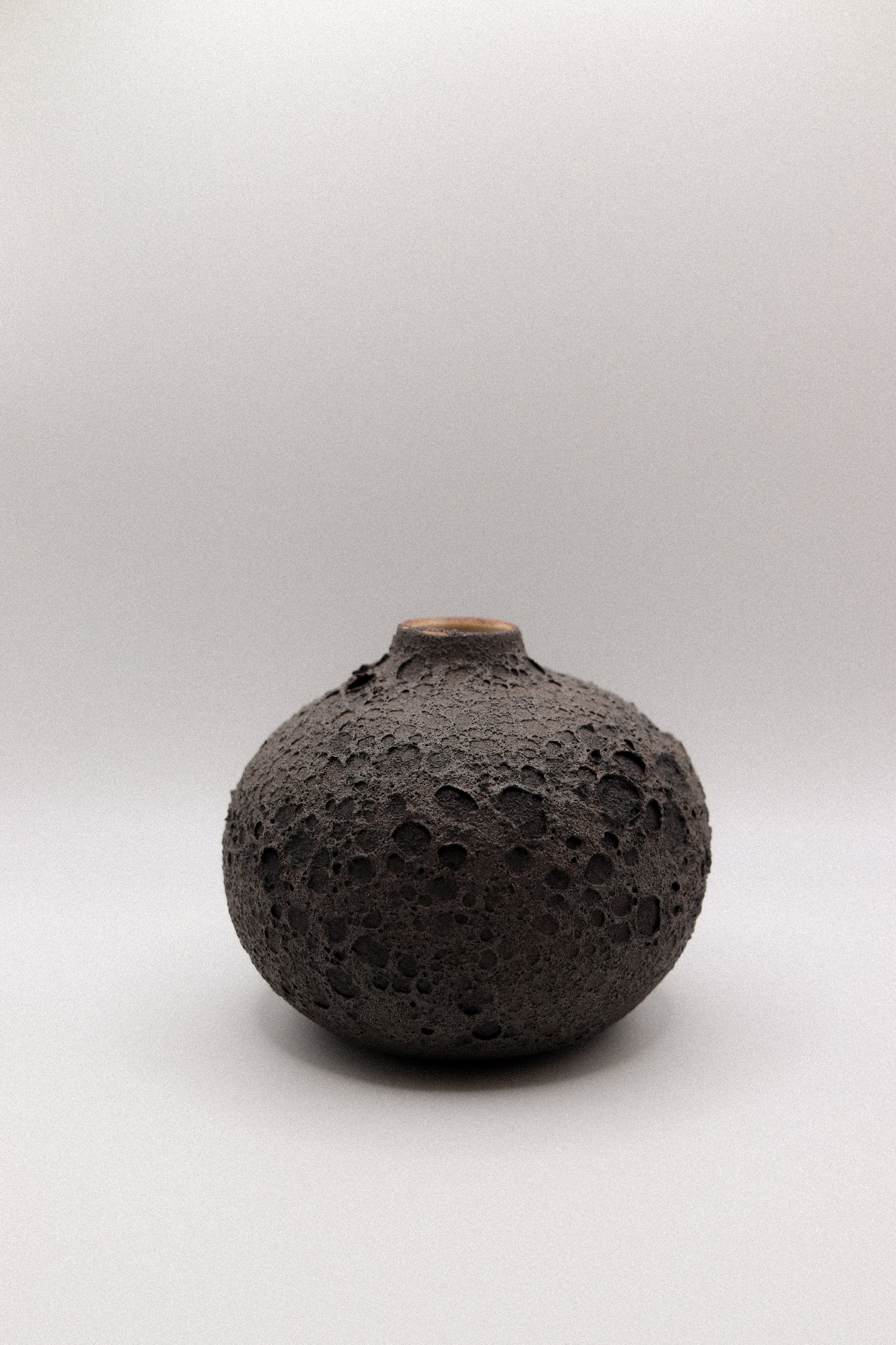 Black textured ceramic vase on a white background