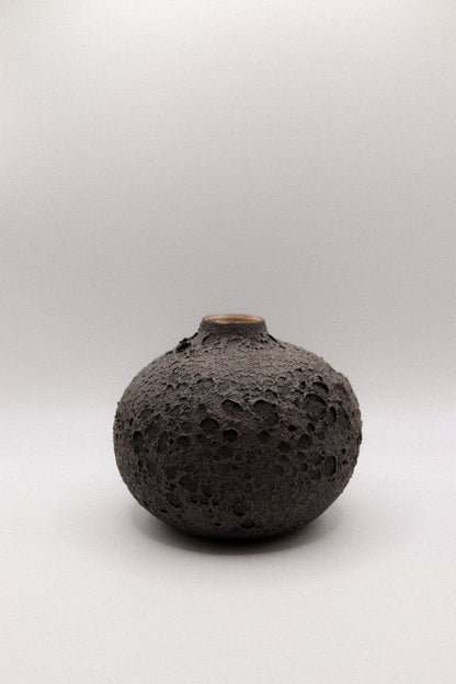 Black textured ceramic vase on a white background