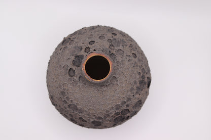 Black textured ceramic vase on a white background