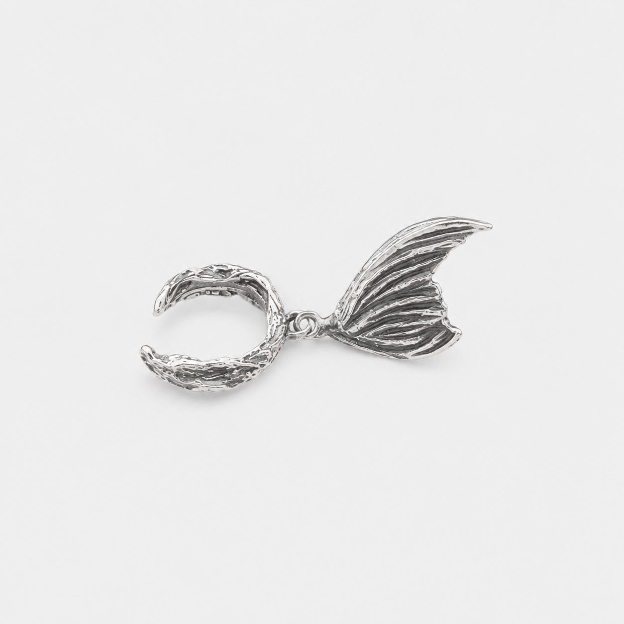 Silver mermaid tail charm on a white background