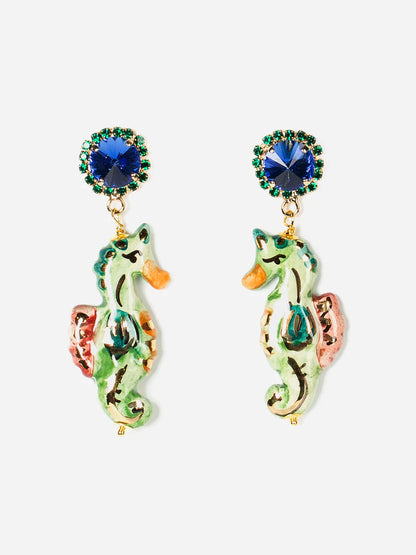 Colorful seahorse-shaped earrings with blue gemstones on a white background