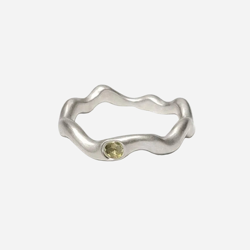 Silver ring with a yellow gemstone on a white background