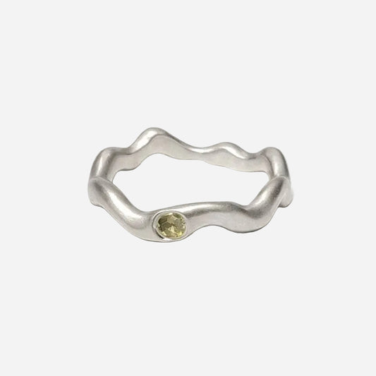 Silver ring with a yellow gemstone on a white background