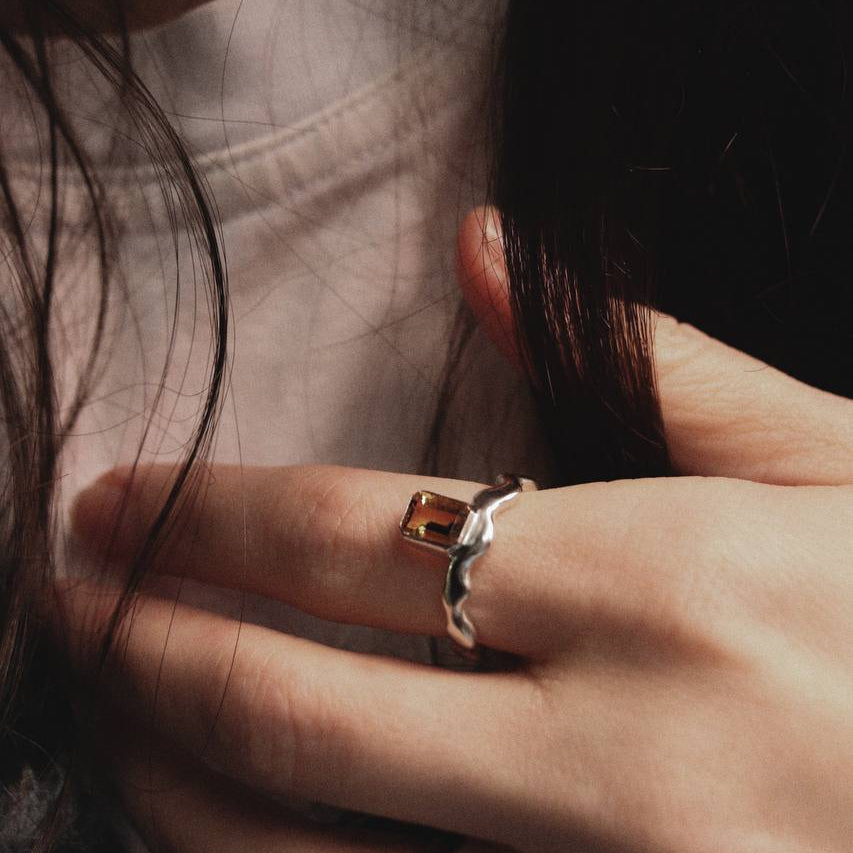 Close-up of a hand wearing two rings with a blurred background