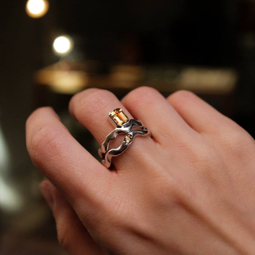 Close-up of a hand wearing two rings with a blurred background