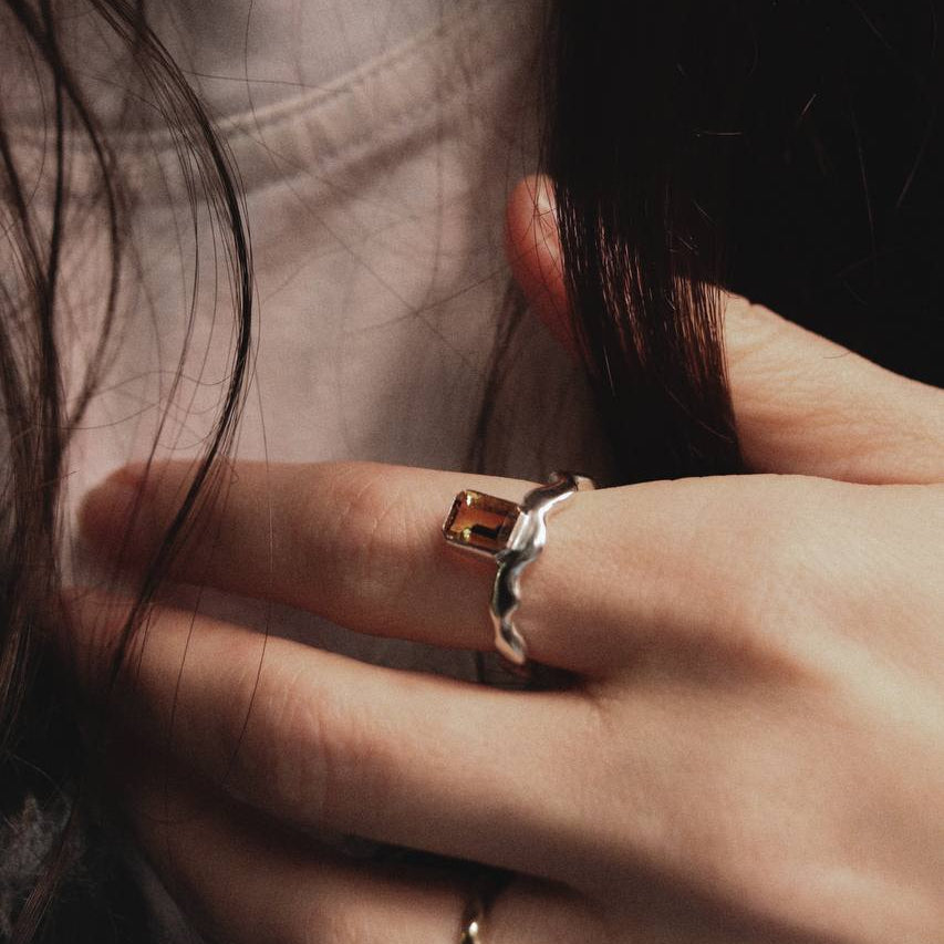 Close-up of a hand wearing two rings with a blurred background