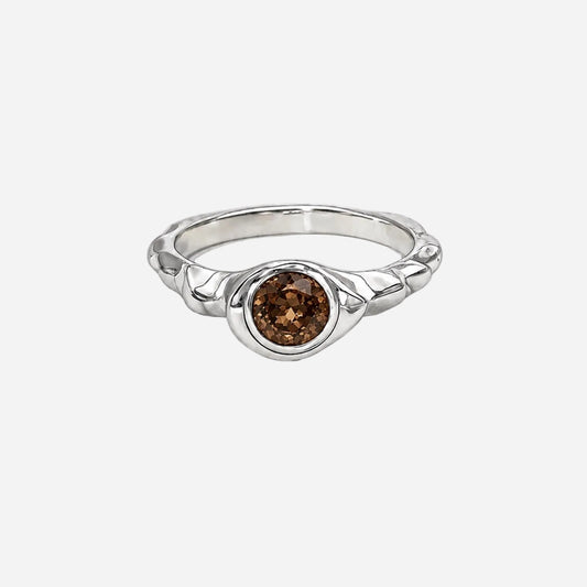 Silver ring with a brown gemstone on a white background