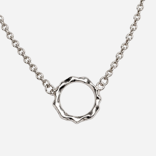 A silver chain necklace featuring a textured, hammered circular pendant with a scalloped edge, displayed against a clean white background.