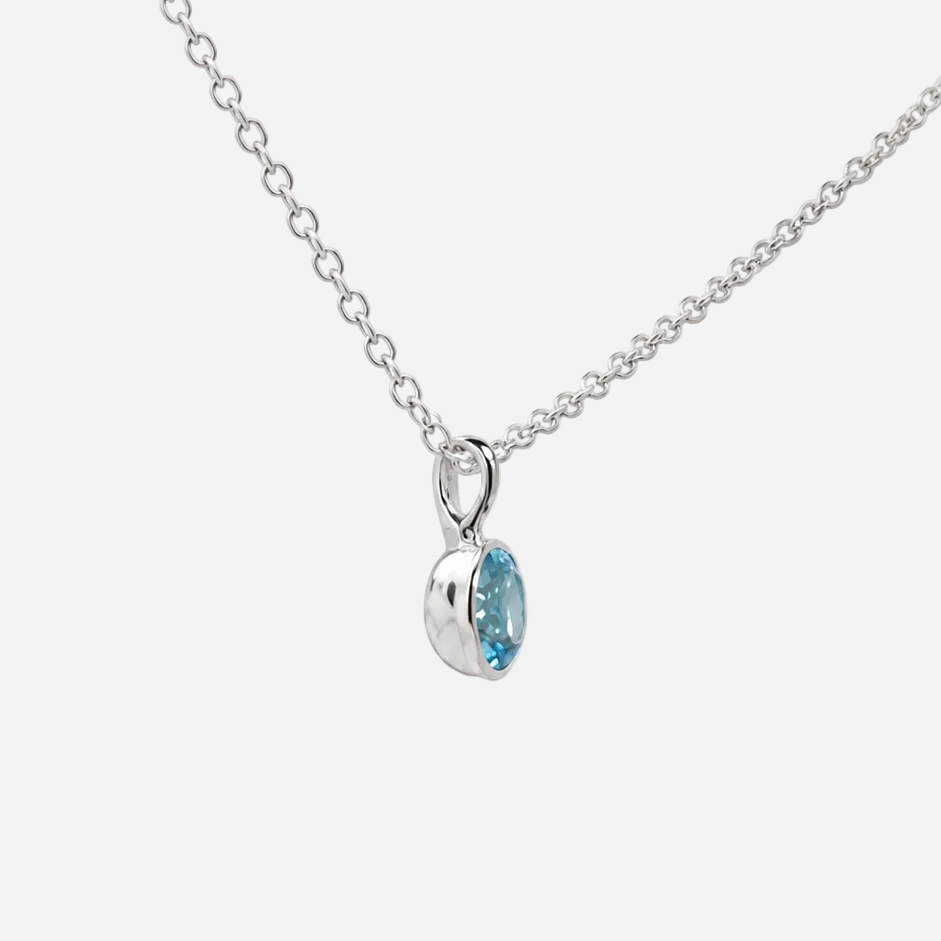 A silver chain necklace with a small teardrop-shaped pendant featuring a light blue gemstone, shown against a plain white background.