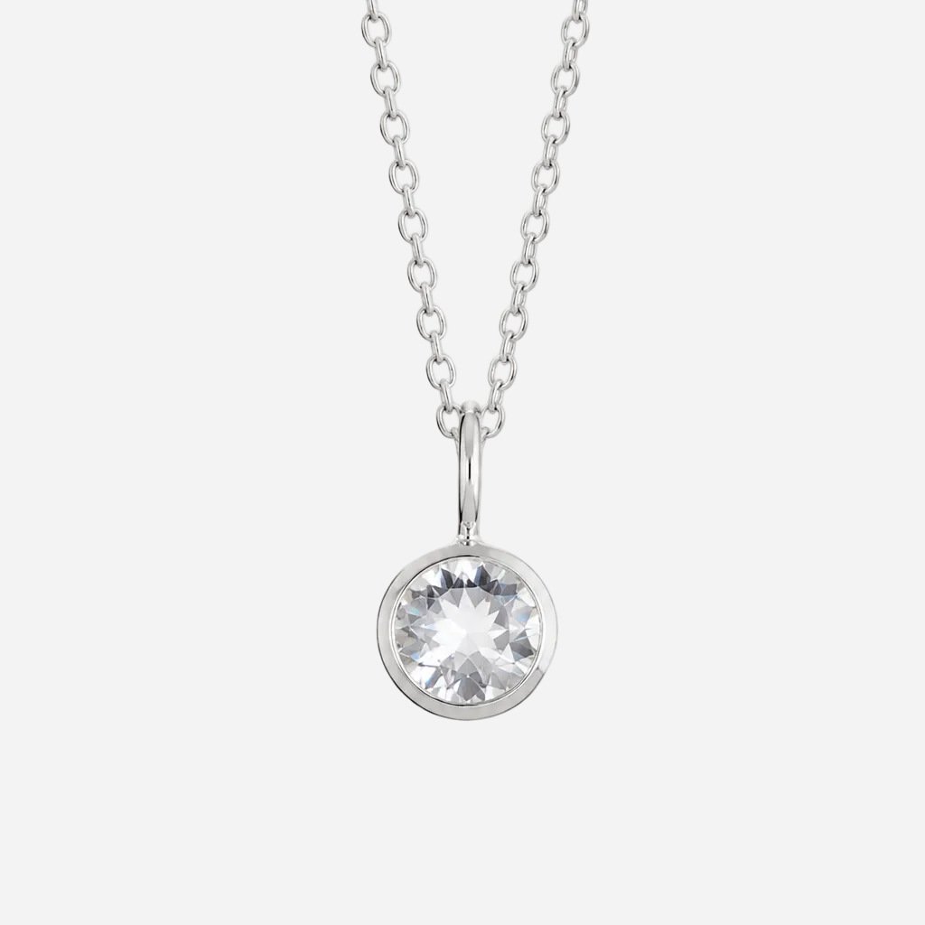 A silver chain necklace with a round bezel-set clear gemstone pendant, shown against a plain white background.