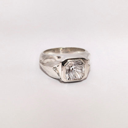 Silver ring with a large diamond on a white background