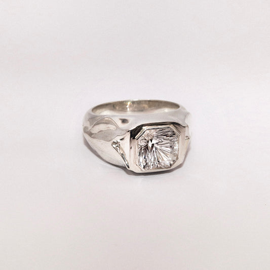 Silver ring with a large diamond on a white background
