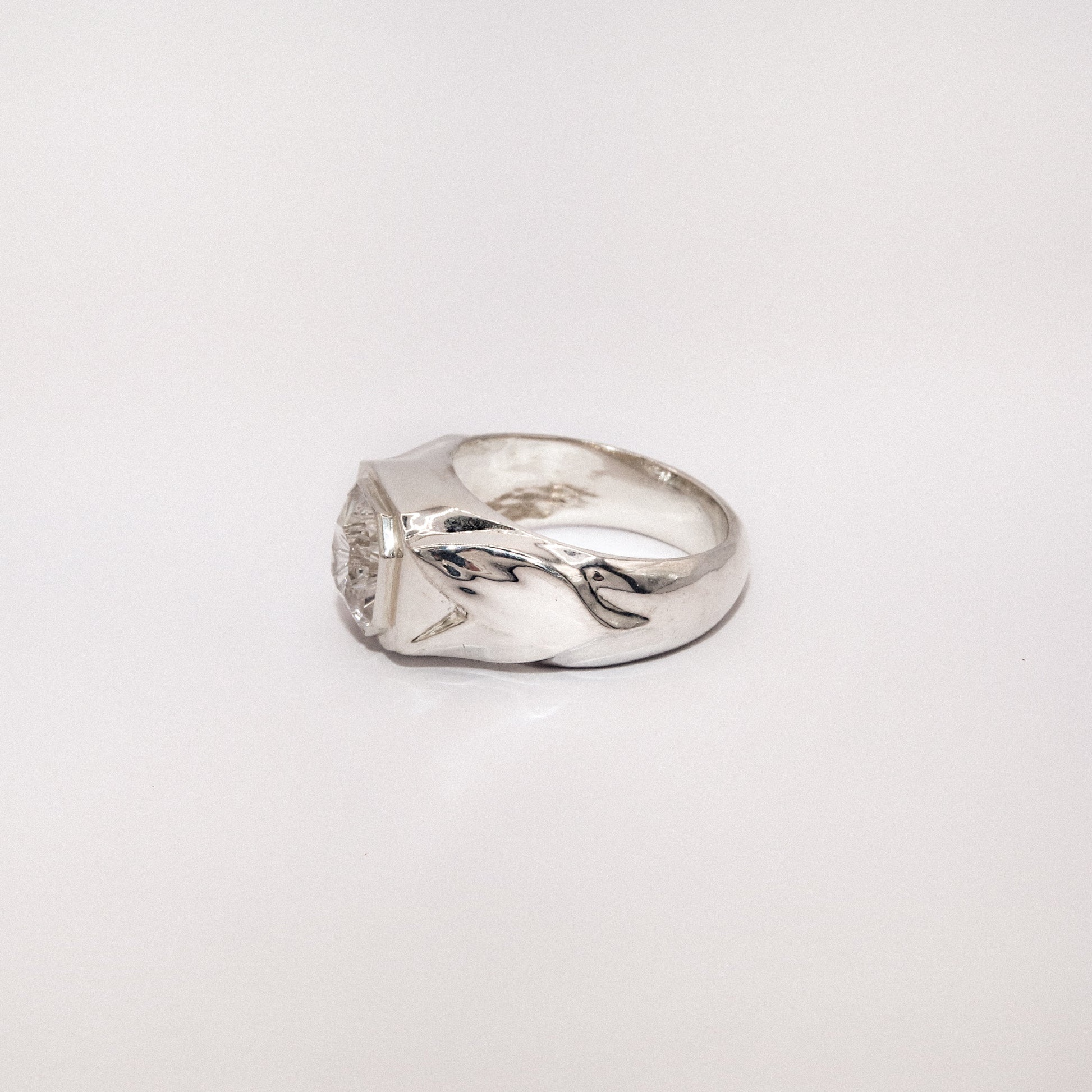 Silver ring with a unique design on a white background